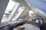 Beispiel 3: Die Kombination Lichtlösung Lichtband von VELUX vergrößert optisch den Raum unterm Dach und unterstützt das besondere Wohn-Ambiente.