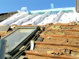 Dachsanierung: alte Dämmwollreste zwischen der Lattung unten - oben bereits Dachfolie zwischen den Dachsparren